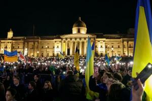 戦争の終結を願って集会に参加するウクライナ避難民ら=24日、ロンドン(共同)