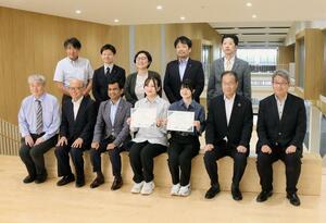 奨学生認定式に臨んだ對馬彩七さん(前列右から3人目)、本田彩音さん(同4人目)と、大学や日本精機の関係者=三条市上須頃