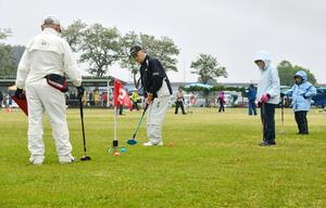 雨の中、約２３０人が腕を競ったグラウンド・ゴルフの大会＝２１日、三条市上須頃