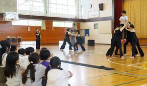 Noism2のメンバーに支えられながら、舞踊家の身体の使い方を体験する東青山小学校の5年生=新潟市西区青山