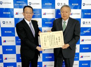 原田健史東京税関長(左)から、委嘱状を受け取る近藤光雄さん=新潟市中央区竜が島1