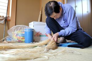 丹念に綱を編み進める達摩組の笹井忠治さん=新潟市南区西白根