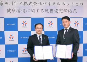連携協定を結んだバイタルネット上越支店の大村圭支店長（右）と久保田郁夫市長＝糸魚川市役所