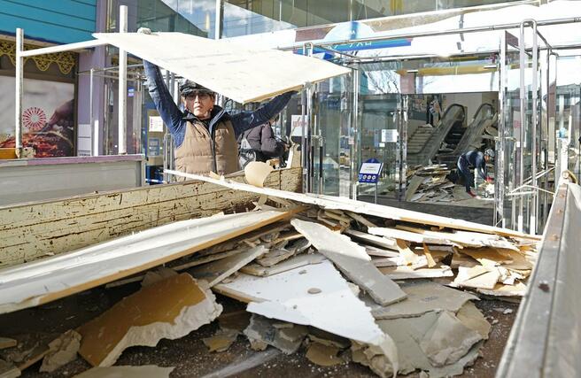強い地震があった青森県八戸市で損壊した商業施設の後片付けをする男性＝９日午前１０時５０分