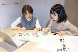 活動史の制作に励む鈴木愛香さん（左）と梁取あすかさん＝新潟市中央区