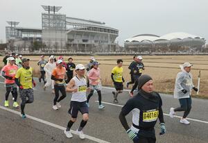 小雨が降る中、ランナーたちが田園地帯を駆け抜けた新潟ハーフマラソン=3月16日、新潟市中央区