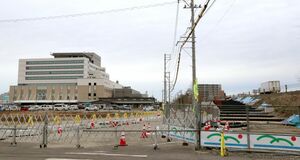 済生会新潟県央基幹病院(左)に隣接する北陸自動車道で建設されているスロープ(右)。救急搬送時間の短縮に向け、ハード面の整備も進んでいる=三条市上須頃