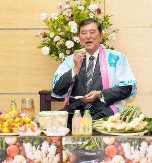 「JAわかやま」から贈られたショウガの漬物をまぜたおにぎりを試食する石破首相=12日午後、首相官邸