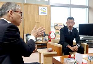 パラトライアスロンのアジア選手権での優勝を報告する永田務さん(右)=村上市役所