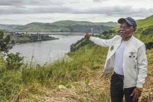 コンゴのマタディ橋を望む高台で建設の経緯を振り返るディコレレ。完成時には「ついに人々の命を救うものができたと思った」と感慨に浸ったという=2025年4月(撮影・中野智明、共同)