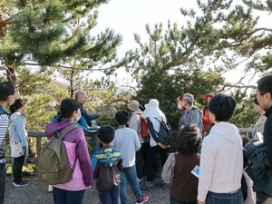 陸から海の景色や植生を学ぶ参加者=11月4日、佐渡市北狄