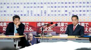 東京都議選の開票速報を見つめる自民党の木原選対委員長(左)と東京都連の井上会長=22日夜、永田町の党本部