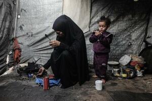 6日、ガザ中部デールバラハのテントで避難生活を送る女性と子ども(ゲッティ=共同)