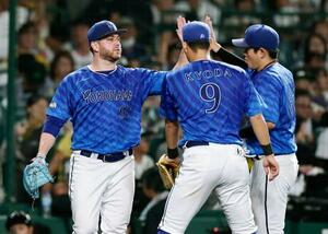 7回を終え、好守を見せた右翼手蝦名(右)とタッチを交わすDeNAのケイ=甲子園