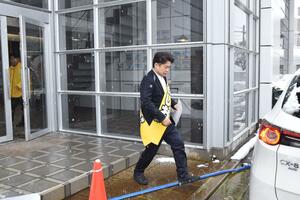 企業の朝礼で自身をアピールした後、足早に次の企業へと向かう鷲尾英一郎＝２日午前８時３０分ごろ、長岡市