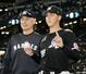 プロ初勝利を挙げ、ウイニングボールを手に吉井監督（左）とポーズをとるロッテ・田中晴＝エスコンフィールド