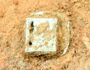 出土した青銅製のベルト飾り「巡方」=4月、長野市の南宮遺跡内(同市埋蔵文化財センター提供)
