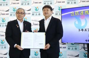 包括連携協定を結んだトキエアの長谷川政樹社長(右)と高橋邦芳市長=8月2日、村上市