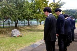 小型プロペラ機の墜落事故から10年となり、碑の前で黙とうする東京都港湾局の職員ら=26日午前、東京都調布市