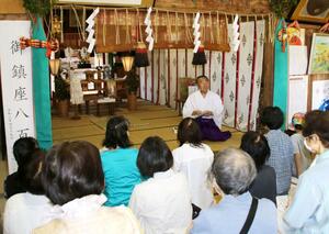 若宮神社の宮司から神社の歴史を聞くバス巡りの参加者ら=五泉市能代