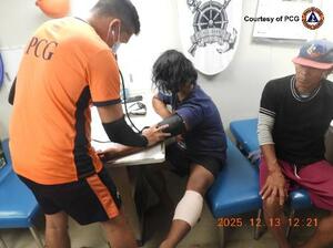 南シナ海で負傷し、手当てを受けるフィリピン漁船の漁師=13日(フィリピン沿岸警備隊提供・AP=共同)