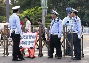 北京市内で車両の通行を規制する警察官=16日(共同)