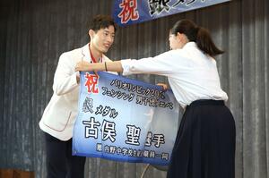 内野中の生徒から横断幕を受け取り、笑顔を見せる古俣聖選手(左)=9月9日、新潟市西区内野西1