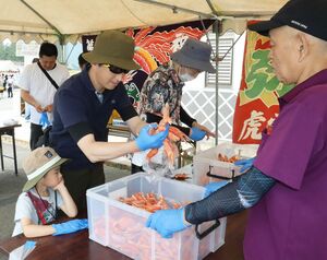 多くの来場者がカニ料理やつかみ取りなどを楽しんだ「赤泊カニフェスタ」=6月9日、佐渡市赤泊