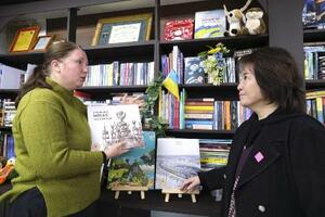 図書室の本棚の前で言葉を交わす村上ダリヤさん(左)と浮世満理子さん=2月、東京・渋谷