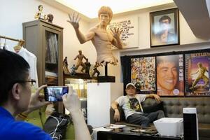 ブルース・リーのファンクラブ「李小龍会」が運営する展示販売施設で写真を撮るファン=6月30日、香港(共同)