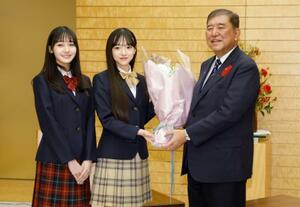 ファッション雑誌「ニコラ」専属モデルの(左から)崎浜梨瑚さん、中瀬梨里さんと写真に納まる石破首相=14日夜、首相官邸