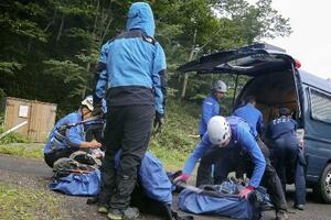 　羅臼岳登山口付近で準備をする捜索隊＝１５日、北海道斜里町