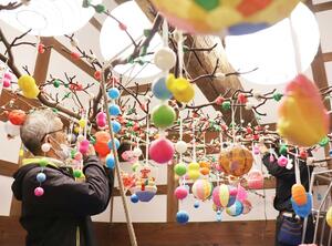 ３色の餅や町特産の紙風船がつるされた繭玉飾り＝出雲崎町尼瀬