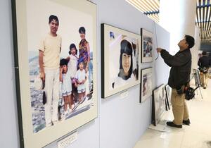 幼少期から拉致被害に遭うまでの横田めぐみさんの写真などを紹介するパネル展の設置作業=12日、新潟市中央区