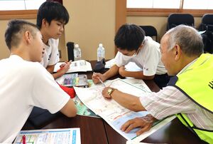 災害時の避難について防災士と確認する出雲崎中の生徒=出雲崎町沢田