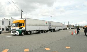 亀田製菓グループが定期運行を始めたダブル連結トラックの出発式=新潟市江南区