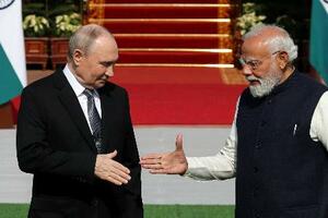 5日、会談前に握手するインドのモディ首相(右)とロシアのプーチン大統領=ニューデリー(ロイター=共同)