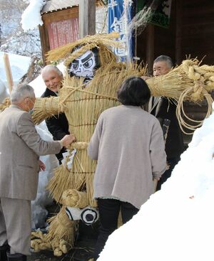 高さ約2メートルの鍾馗様を担いでお堂に運ぶ住民ら