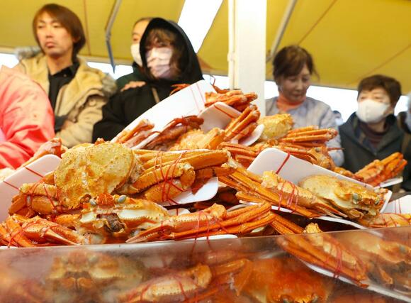 店頭に並んだカニを品定めする買い物客＝３０日、長岡市寺泊下荒町