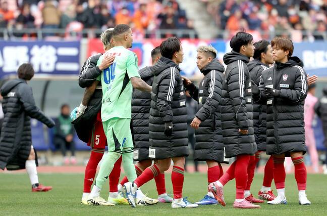 ＰＫ戦負けが決まり、仲間に労われるＧＫバウマン（６４）＝７日、デンカビッグスワンスタジアム