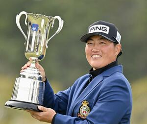通算10アンダーでツアー初優勝を果たし、トロフィーを手に笑顔の工藤遥加=UMKCC