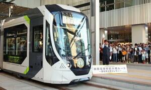広島電鉄の新線「駅前大橋線」が開業し、広島駅電停を出発する一番電車=3日早朝、広島市南区