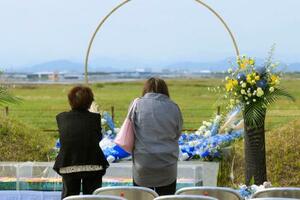 中華航空機墜落事故から32年となり、慰霊施設で献花し手を合わせる女性ら=26日午後、愛知県春日井市