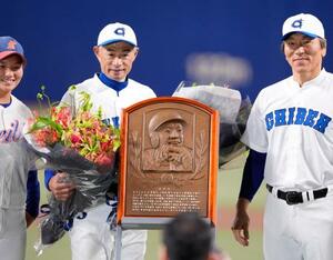 野球殿堂入り表彰式で松井秀喜さん(右)らから花束を受け取り、記念写真に納まるイチローさん=31日、名古屋市のバンテリンドームナゴヤ
