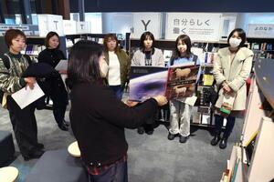 職員から互尊文庫の特徴などについて説明を聞く「ひとりじかん」の参加者=長岡市大手通2