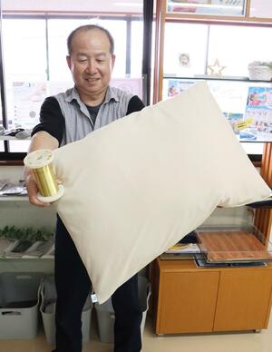 銅繊維を織り込んだ枕カバーをアピールする「HIRAI」の平井純一社長=見附市本町2
