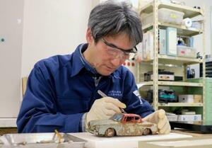 　東日本大震災で被災した玩具を修復する元興寺文化財研究所の雨森久晃さん＝１月、奈良市