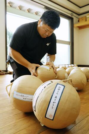 故人へのメッセージを花火玉に貼り付ける石附大昌さん=加茂市上土倉