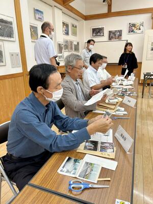 30年前の集落の様子を記録した資料を懐かしむ区長たち=関川村下関