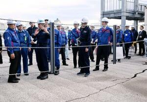 　八戸港を視察し、路面のひび割れなどを確認する金子国交相（左端）＝２０日午後、青森県八戸市